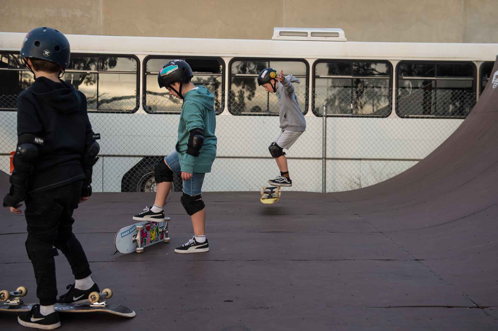 Skaters learn a "Primo Stand" on the outdoor halfpipe at Rampfest Indoor Skatepark