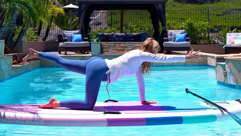 A woman doing SUP yoga in a pool