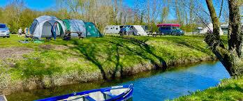 SUP enthusiasts camping at a river bank