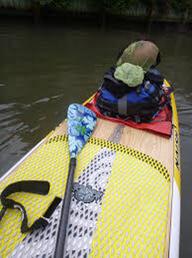 A paddle board packed with camping gear at the back