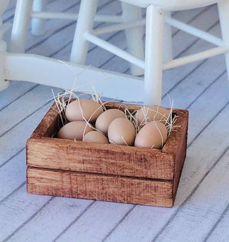 Dollhouse miniature eggs in wooden crate and straw