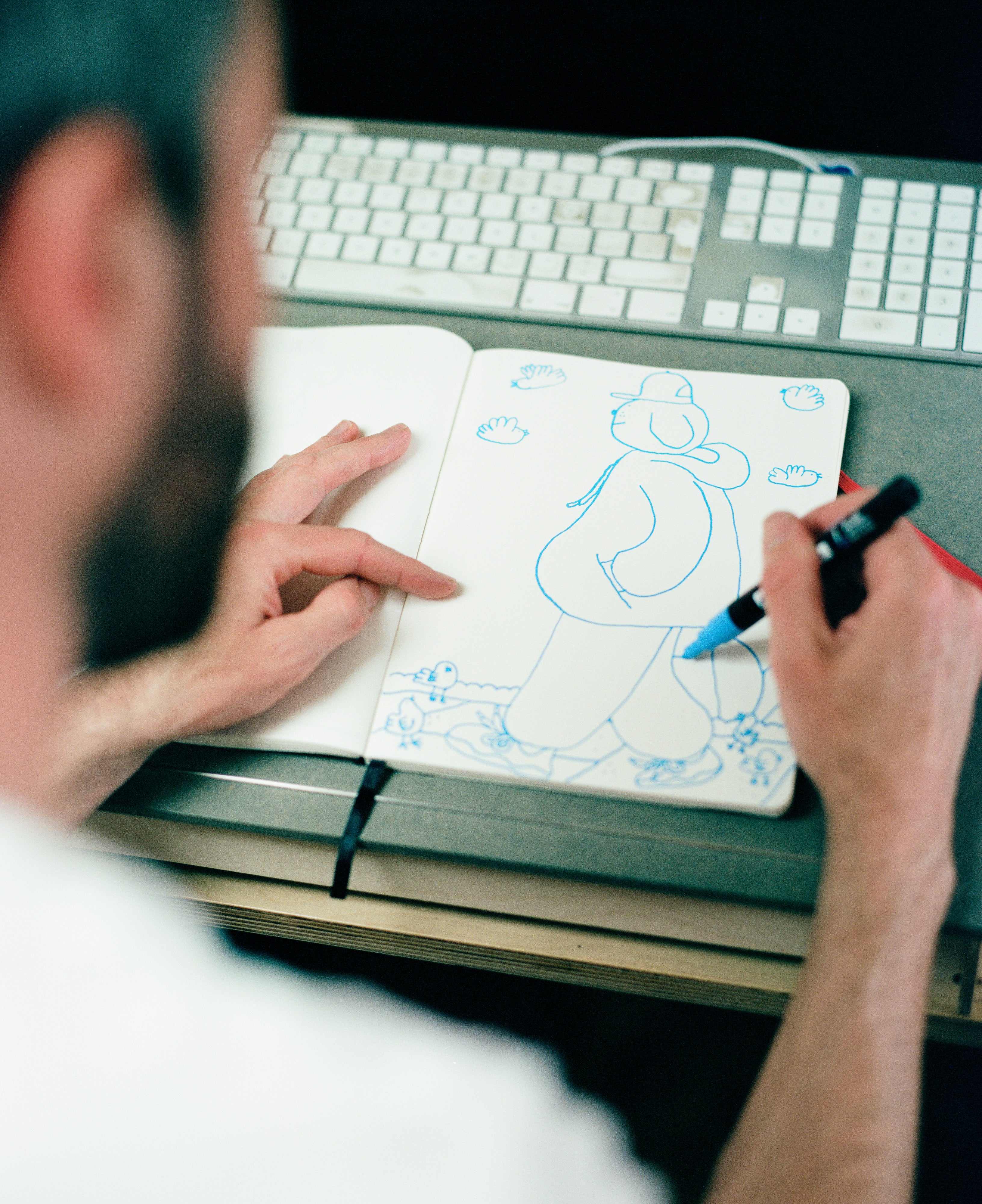 A view over Patrick's shoulder looking at drawing in a sketchbook