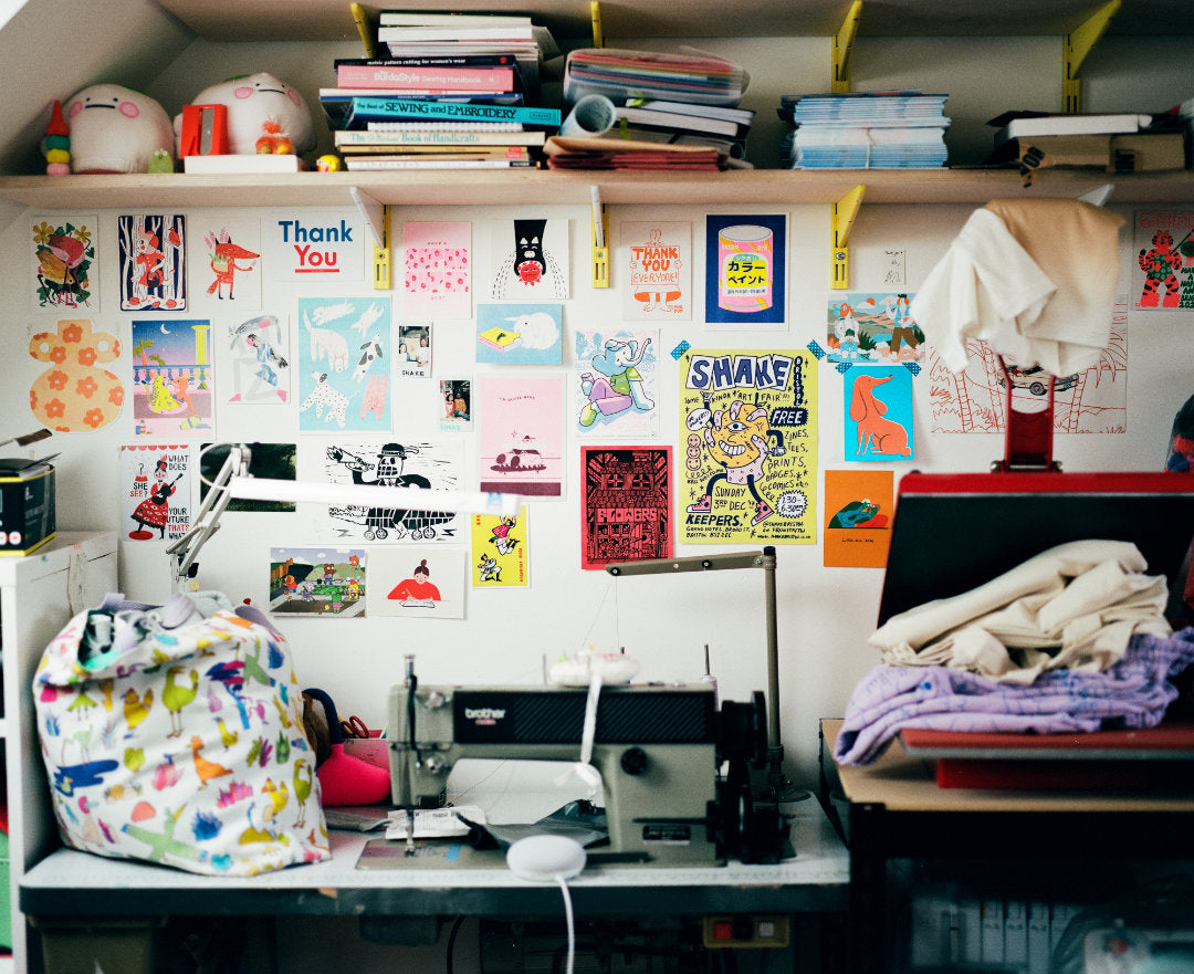 A view of Lucy's sewing machine area which is filled with cards and posters of illustrations