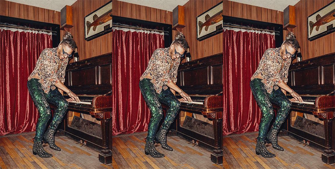 man wearing sequin trousers playing piano