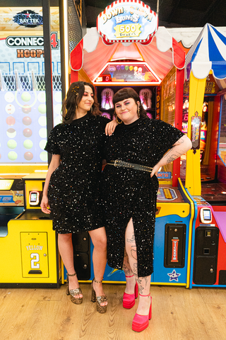 two women wearing black isolated heroes plus size sequin dresses available in sizes 12 - 28