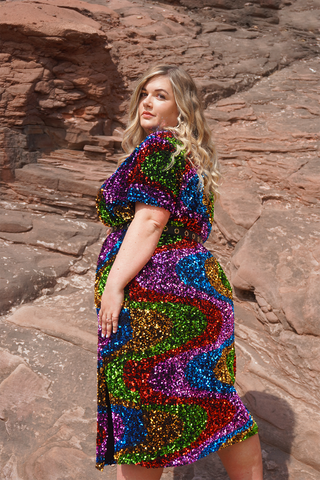 woman wearing an isolated heroes plus size sequin dress in rainbow colours available in sizes 12 - 28