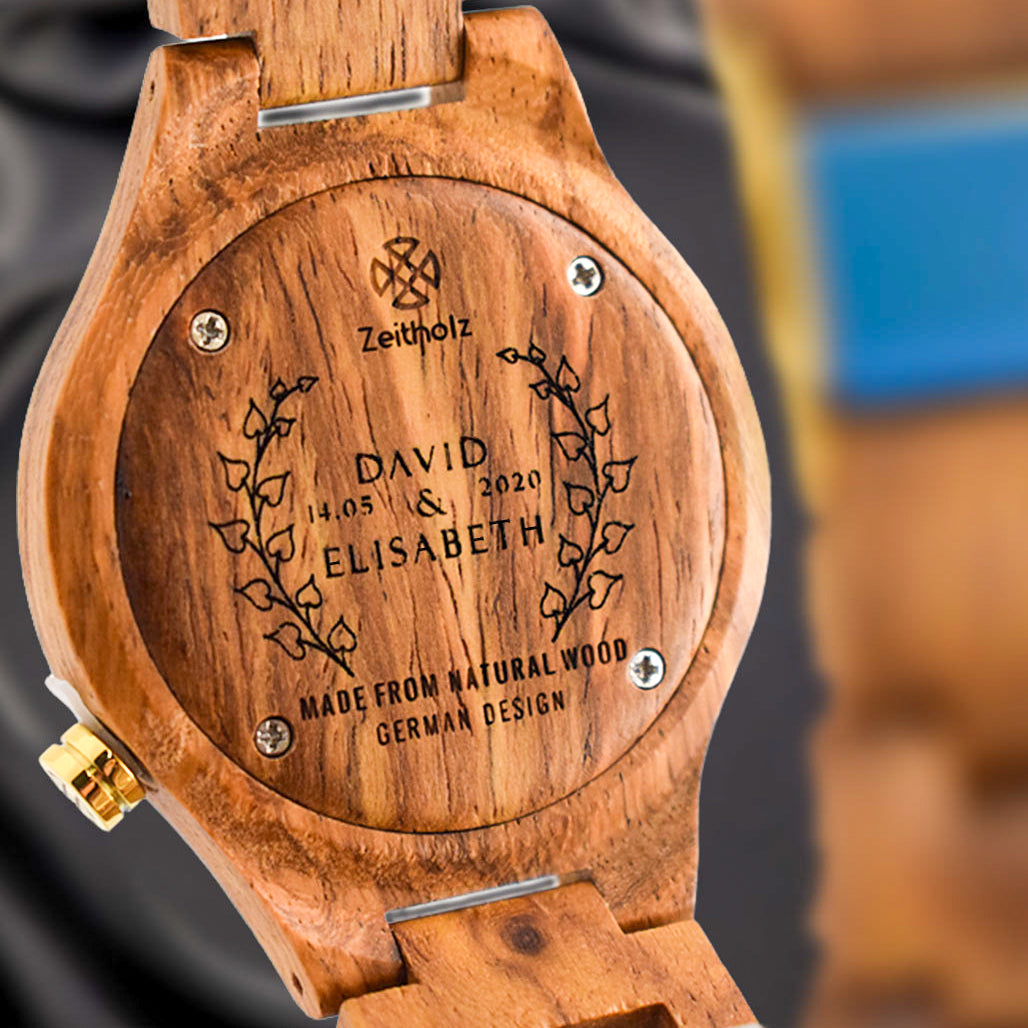 Orologio in legno personalizzato con i nomi David ed Elisabeth, incisione della data circondata da fogliame, realizzato in legno naturale con design tedesco.