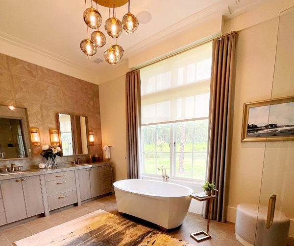 bathroom with bath tub, orb chandelier, wide windows, dual vanity