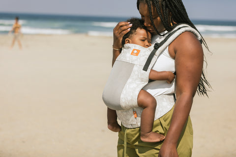 A mother carrying her child in front-inward facing position.