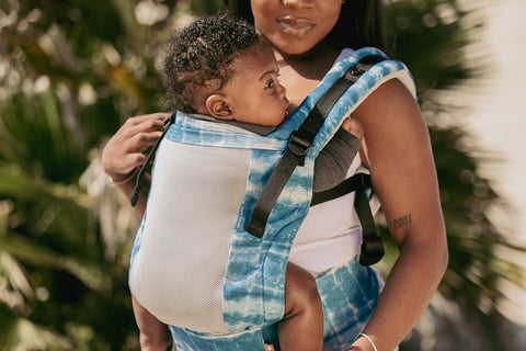 A mother wearing her baby in a Tula Carrier.