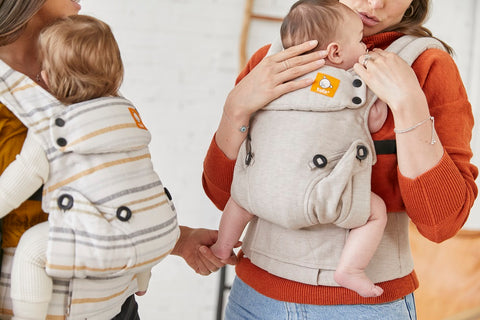 Two moms and their children using Tula Baby Carrier.