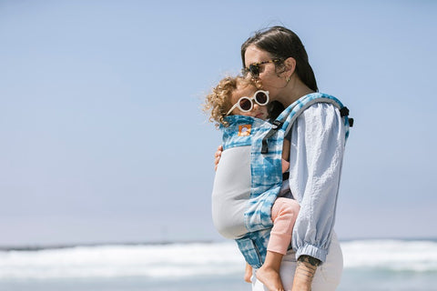 A mother and her child using a Coast Carrier, a great summer carrier, while both are wearing sunglasses.
