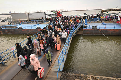 Une grande foule de personnes qui traversent un pont.