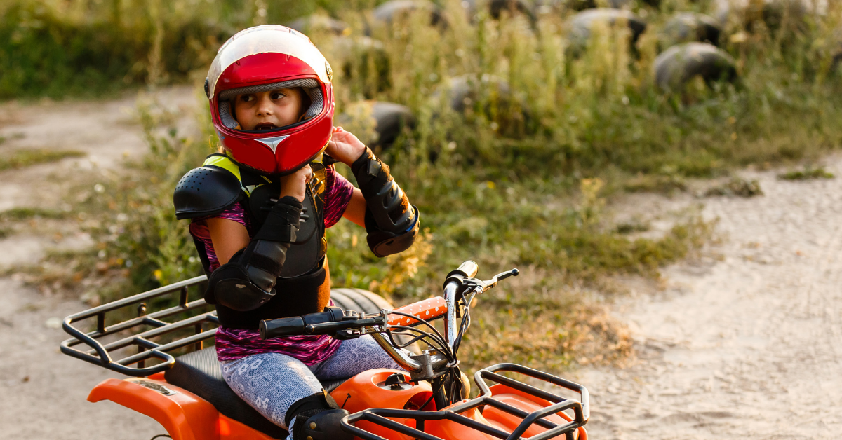 Boy wearing safety gears while quad riding