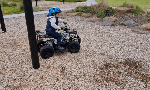Kid riding a kid's quad bike and making a smooth turn