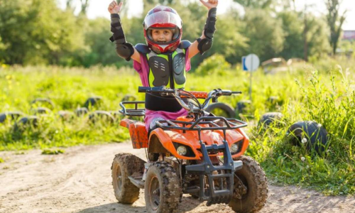 Boy wearing protective gear while driving a quadbike