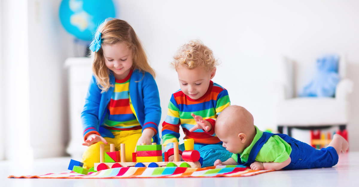 3 kids of different ages playing with their toys