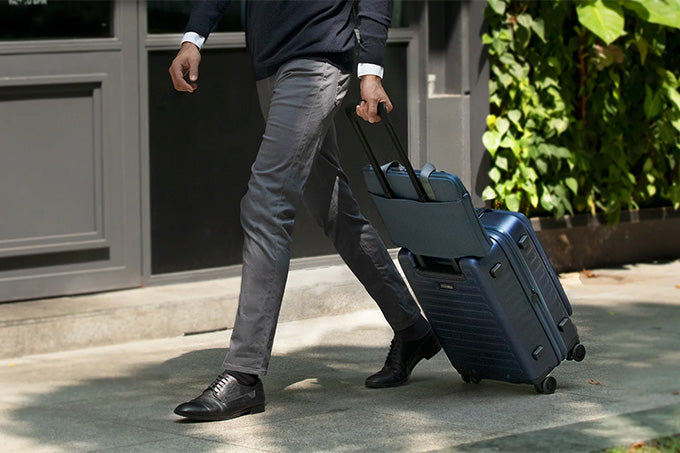 Image of a man carrying his luggage with his laptop