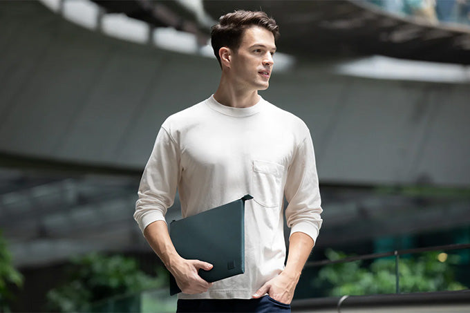 Image of good looking man carrying his laptop