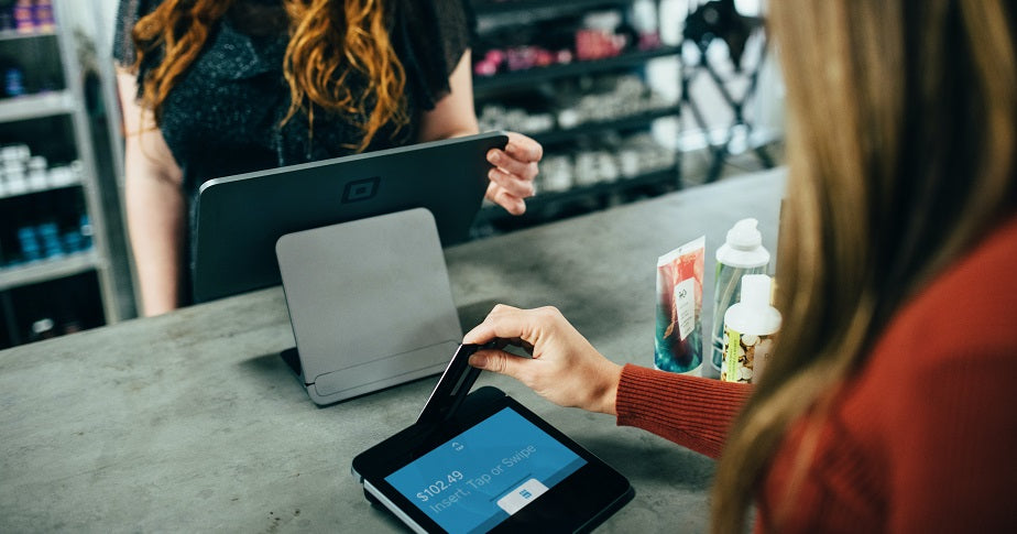 Eine Frau bezahlt an einem POS-System. Welche Lösung für dich die richtige ist, erfährst du im Beitrag.