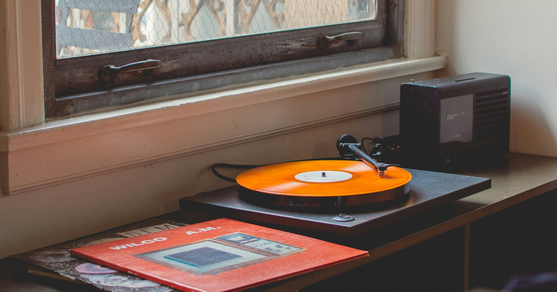 Das Foto zeigt einen Plattenspieler und verschiedene Schallplatten.