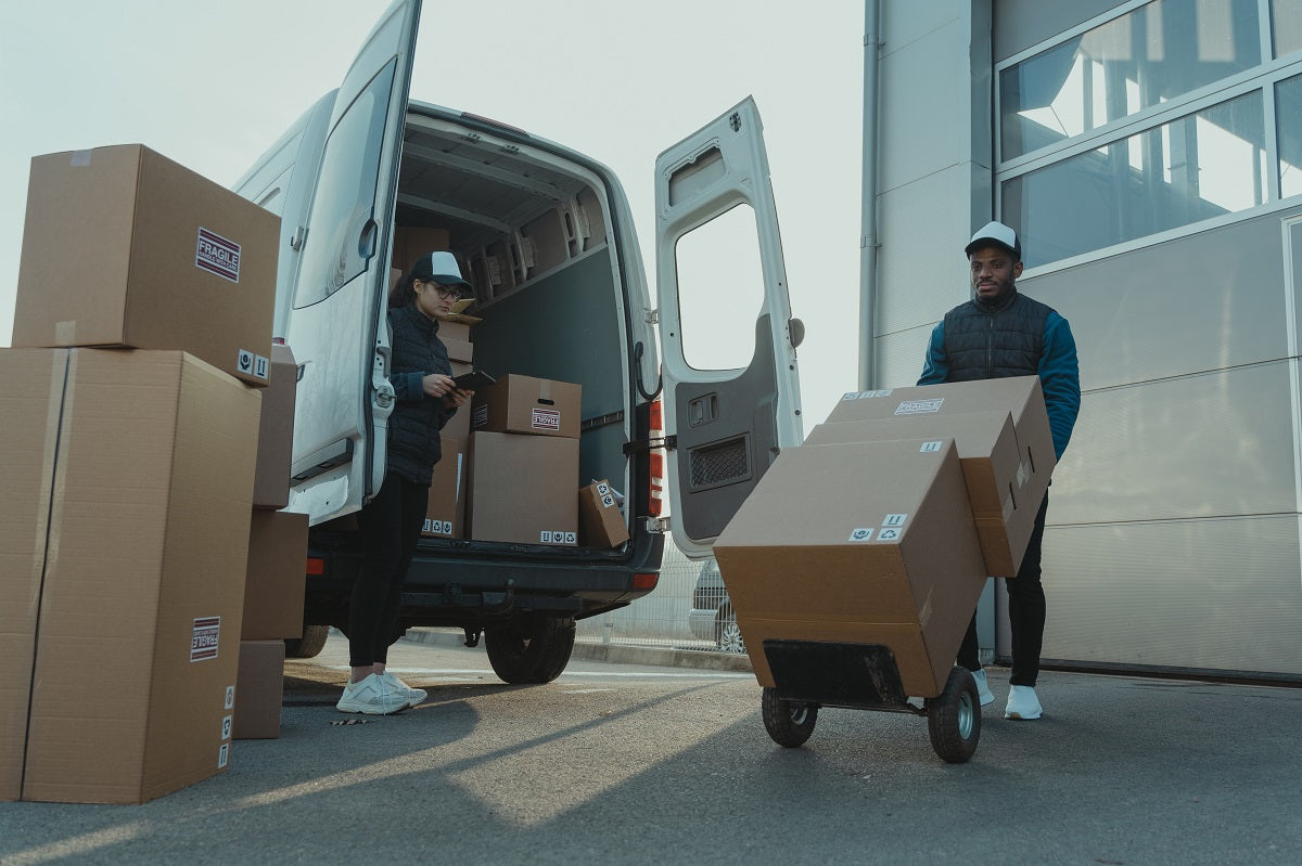 Zwei Männer laden Pakete in einen Transporter. Erfahre mehr über die Funktionen und Prozesse beim 3PL-Modell.