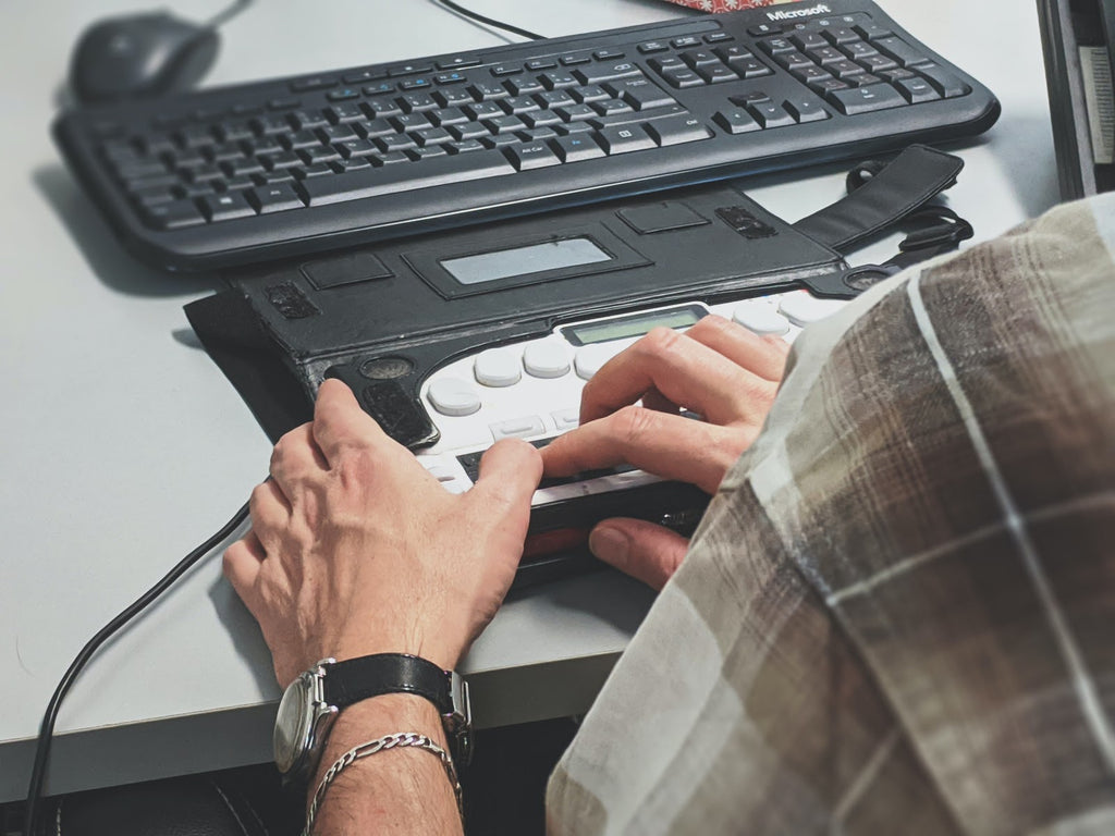 Ein Mann bedient einen PC mithilfe eines speziellen Controllers