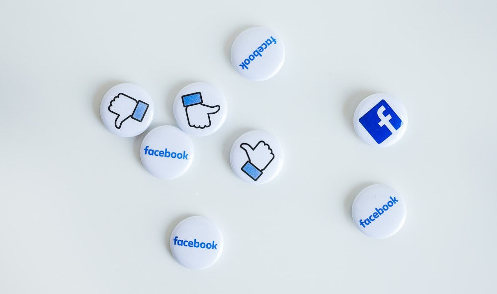 Acht Pins auf denen Facebook steht, ein blau-weißes F oder ein Daumen hoch abgebildet sind.