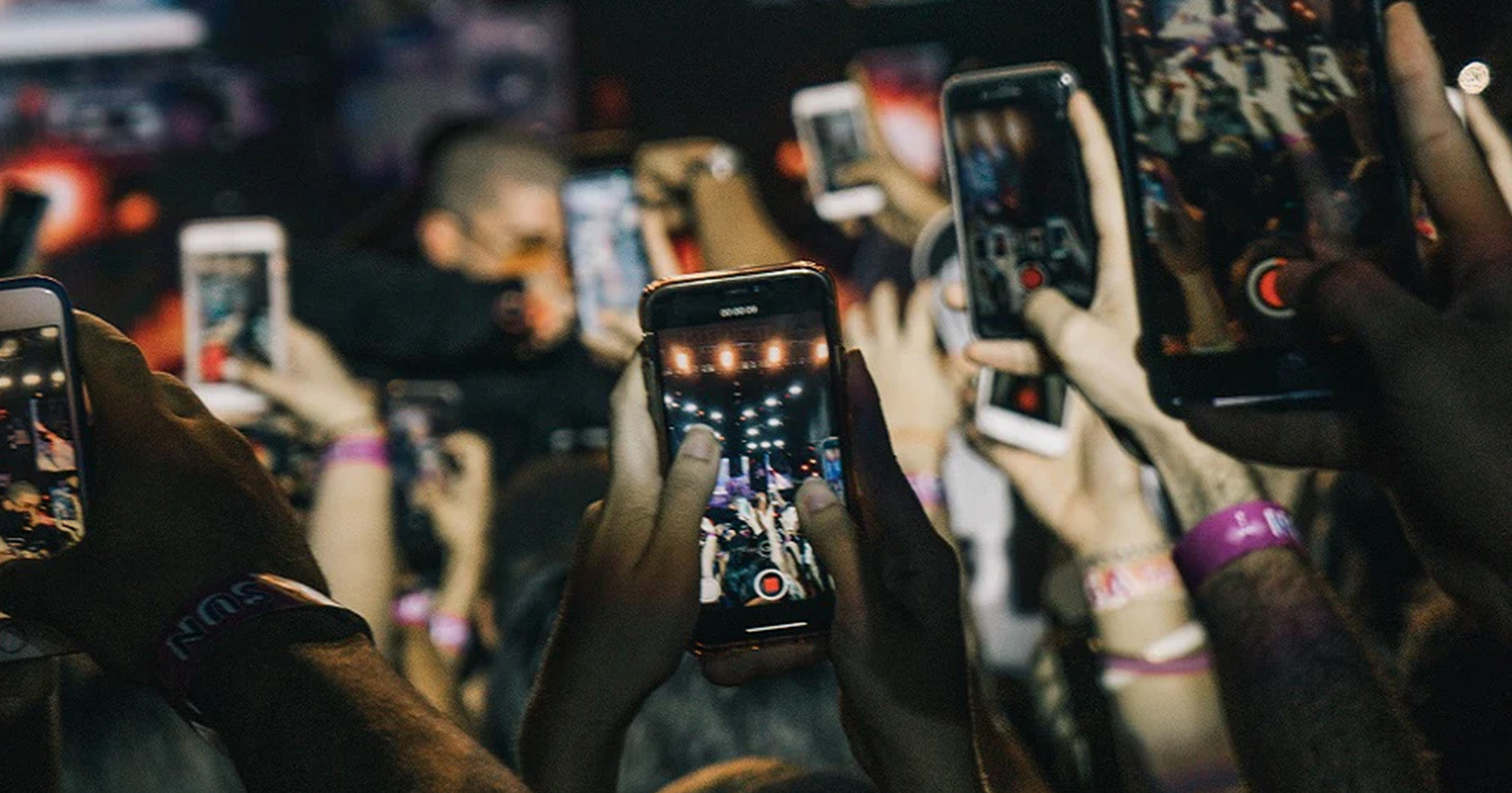 Das Foto zeigt eine Menschenmenge auf einem Konzert, die ihre Handys in die Luft halten und Fotos machen und filmen. Wie du UGC für dein Unternehmen nutzen kannst, erfährst du im Beitrag.