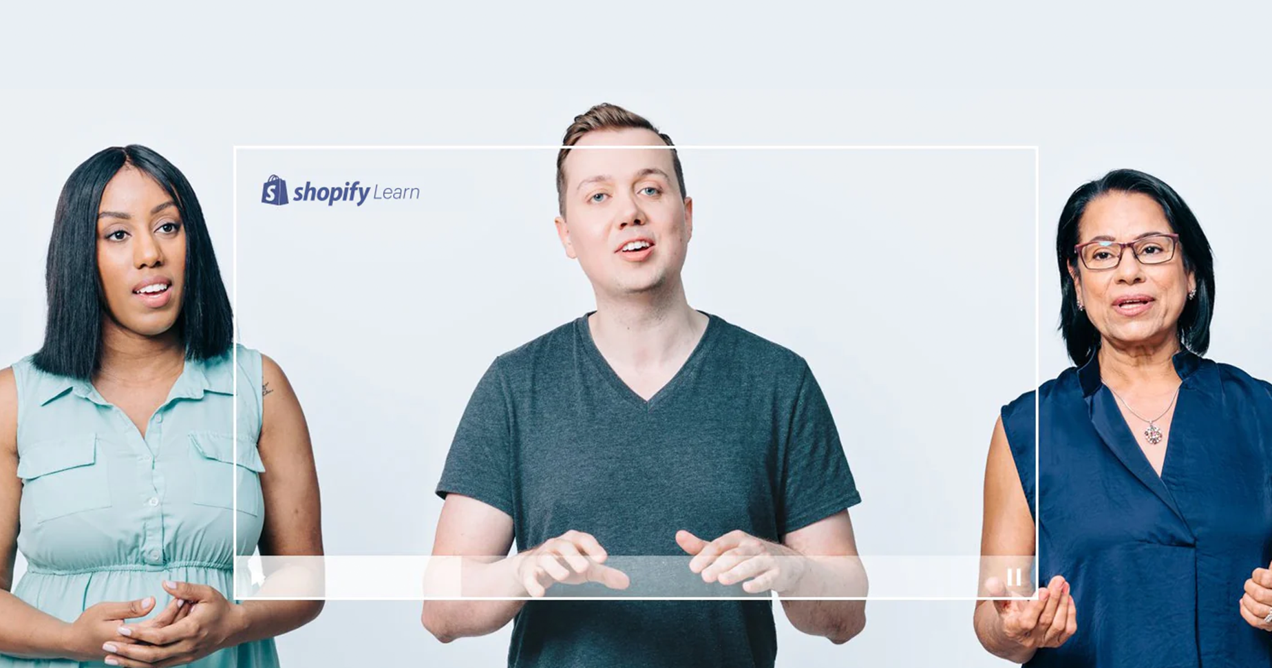 Drei Personen sprechen vor einer hellen Wand zu den Shopify Kursen von Shopify Academy.