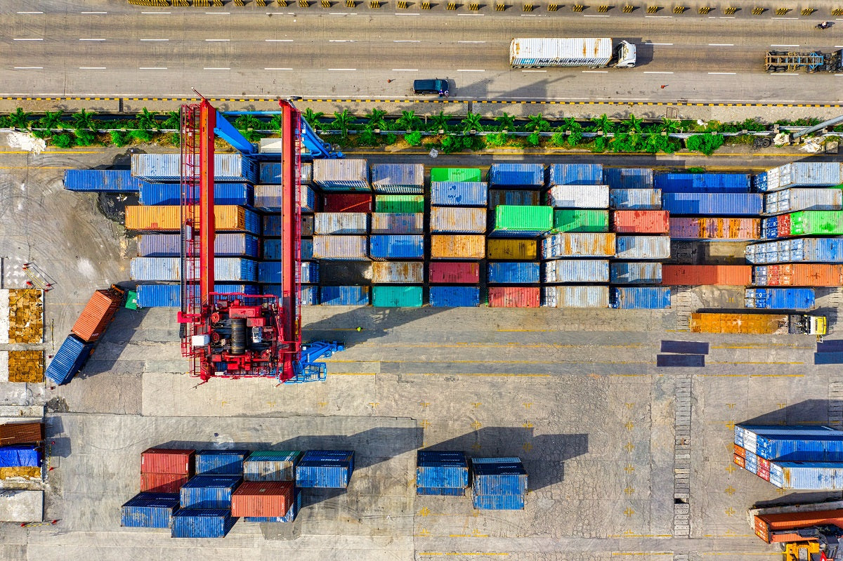 Das Foto zeigt eine Ansammlung von Frachtcontainern, die auf den Weitertransport warten.