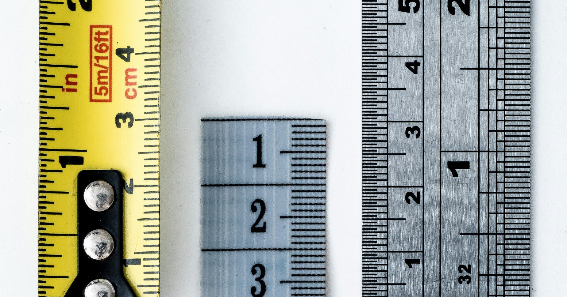 Das Foto zeigt drei Maßbänder, die nebeneinander liegen. Wir zeigen dir in diesem Beitrag, was du für die Bildgrößen auf deiner Website beachten solltest.