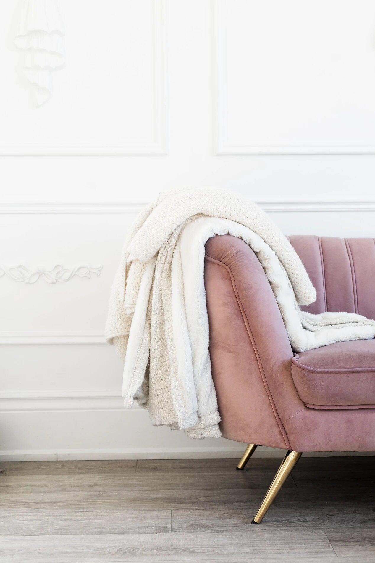 Bild eines rosa Sofas mit dem Trendprodukt 2024 einer weißen Decke