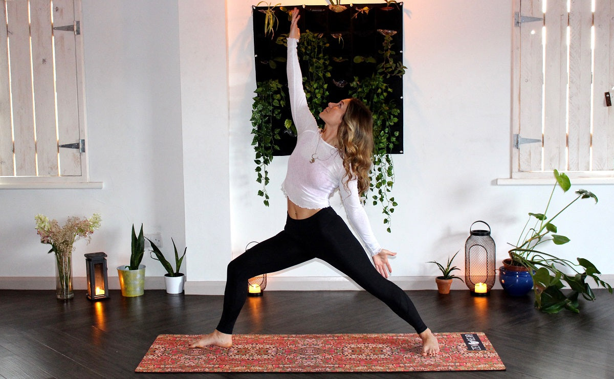 Das Foto zeigt eine Frau, die auf einer Yogamatte eine Yogaübung ausführt.