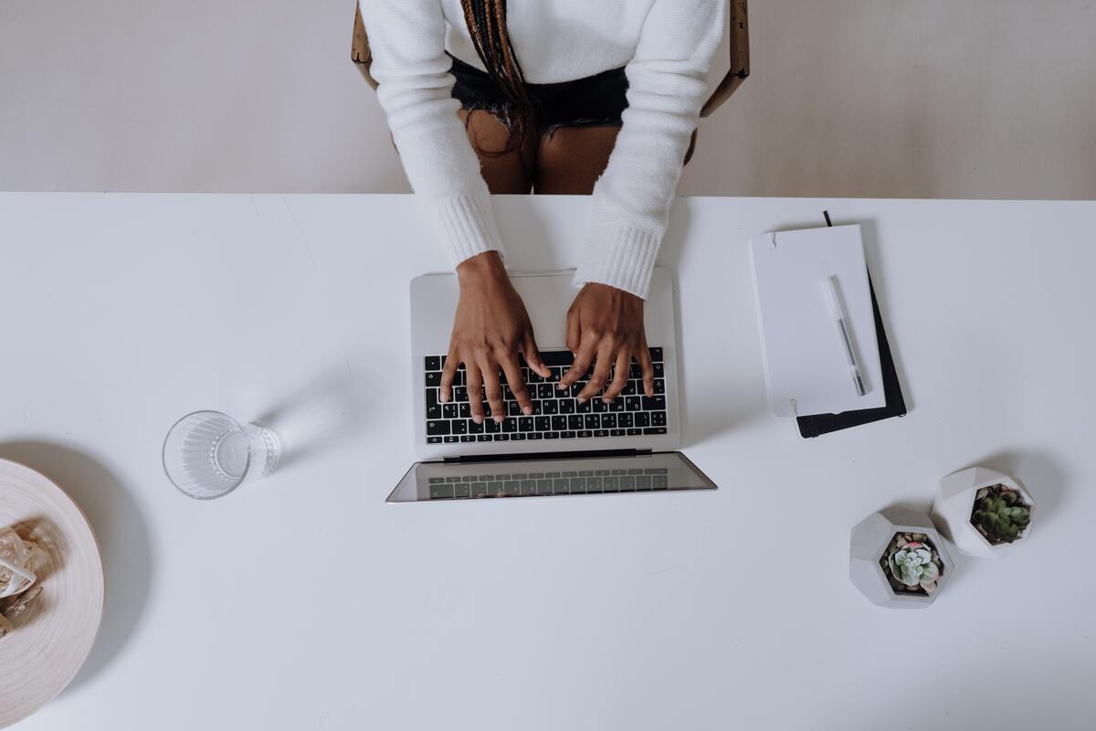 Frau arbeitet an Arbeitsplatz mit Laptop