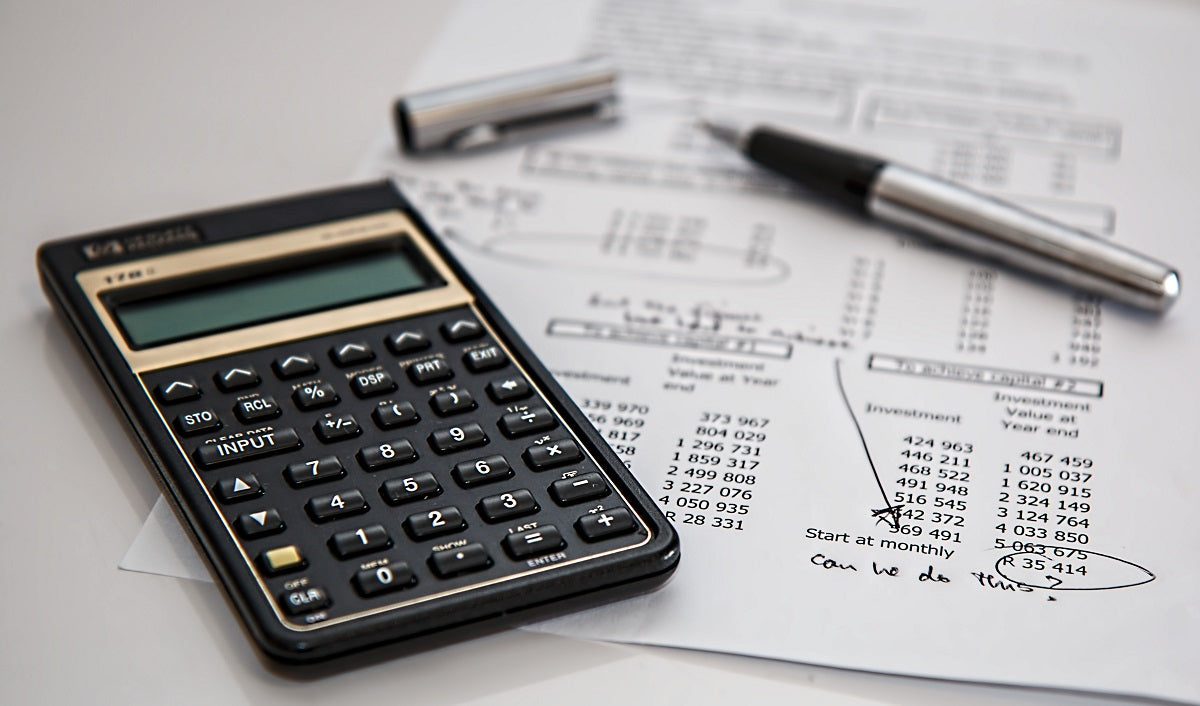 Das Bild zeigt einen Taschenrechner und Unterlagen zur Steuer. Freiberufler:innen haben einige steuerliche Vorteile.