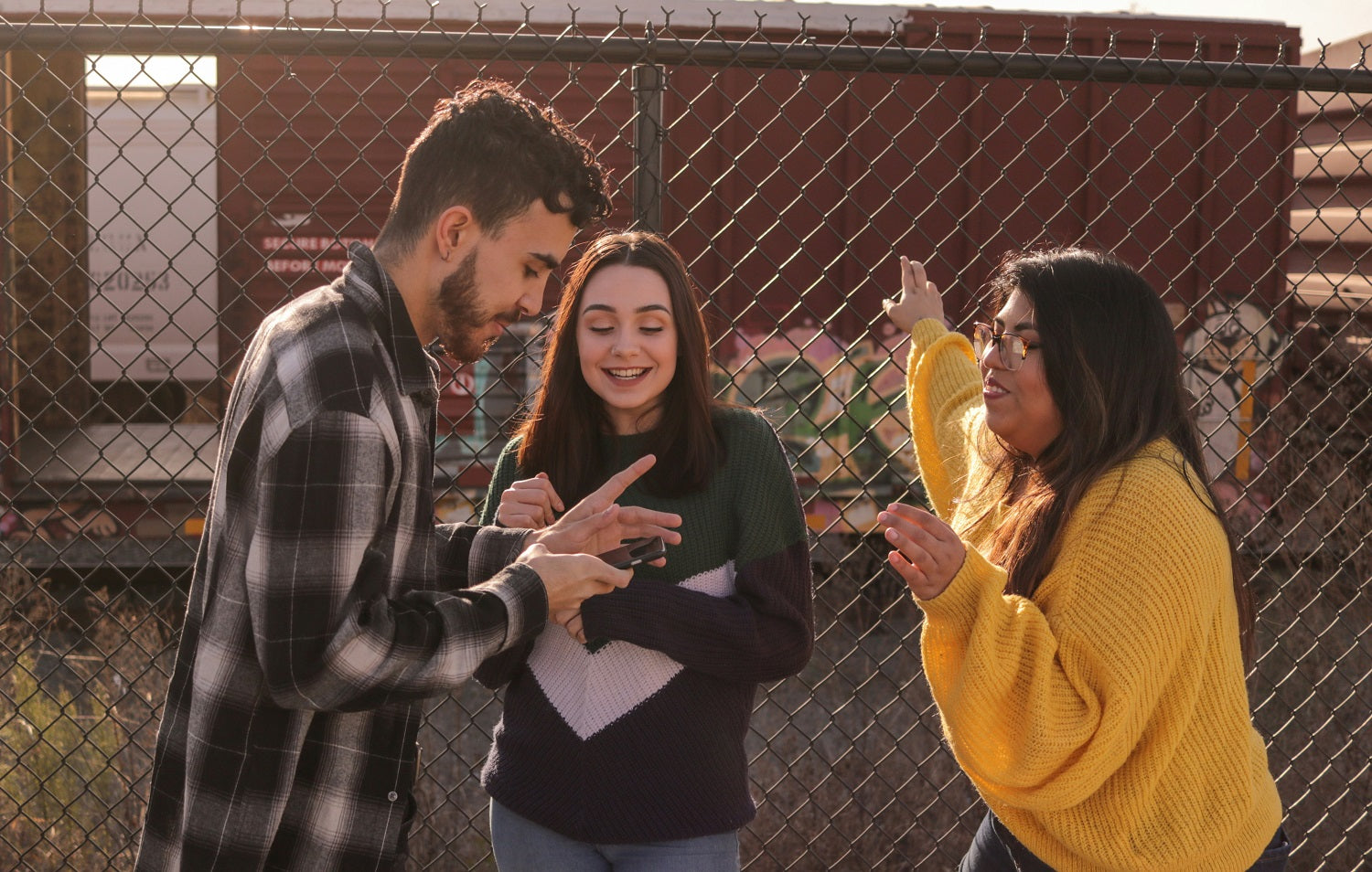Das Foto zeigt drei Teenager, die sich unterhalten.
