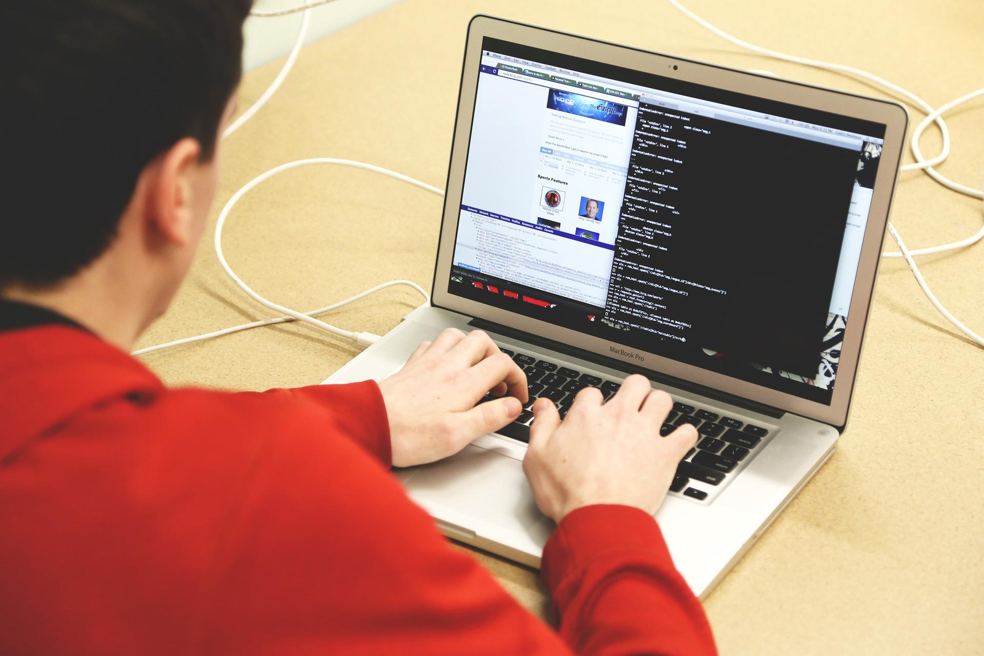 Ein junger Mann sitzt vor einem Laptop und tippt etwas auf der Tastatur. Auf dem Bildschirm sind zwei Fenster geöffnet. Eine Lösung für den HTTP Error 500 kann das Löschen aller Erweiterungen, die du gerade installiert hast, sein.