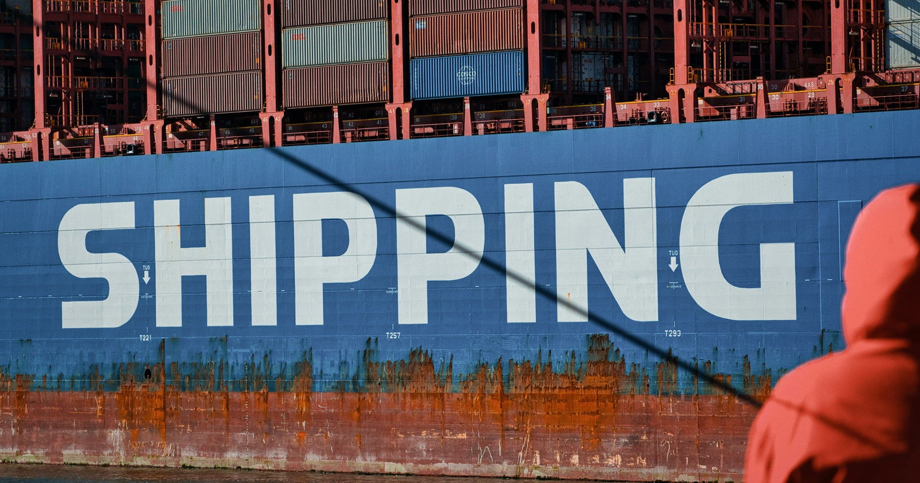 Gezeigt ist ein blauer Container mit der Aufschrift „Shipping“.