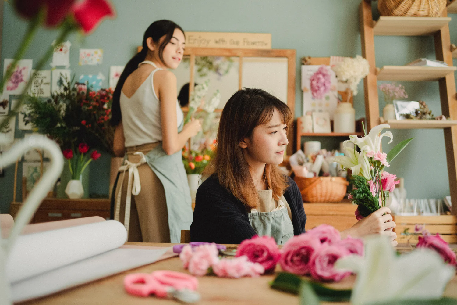 Das Foto zeigt zwei Frauen, die in einem Blumengeschäft arbeiten. Die Rückkehr zum Einzelhandel ist ein weiterer Konsumtrend 2024.