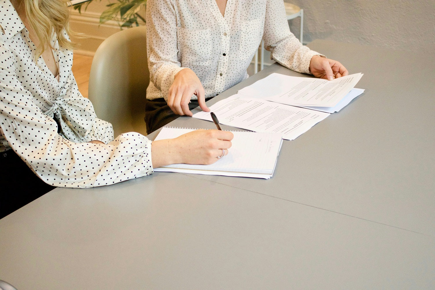 Das Foto zeigt zwei Personen, die einen Vertrag unterschreiben. Welche Dokumente du für einen Kredit für Kleinunternehmer:innen benötigst, erfährst du im Beitrag.