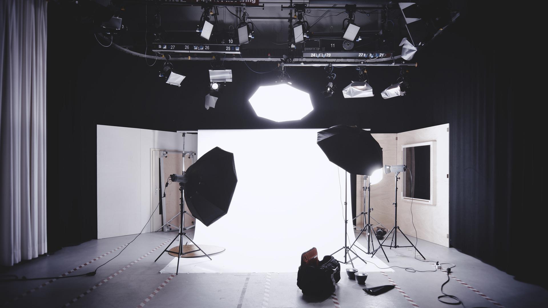 Blick in ein Foto-Studio mit aufgebauter Beleuchtung und einem weißen Hintergrund. 