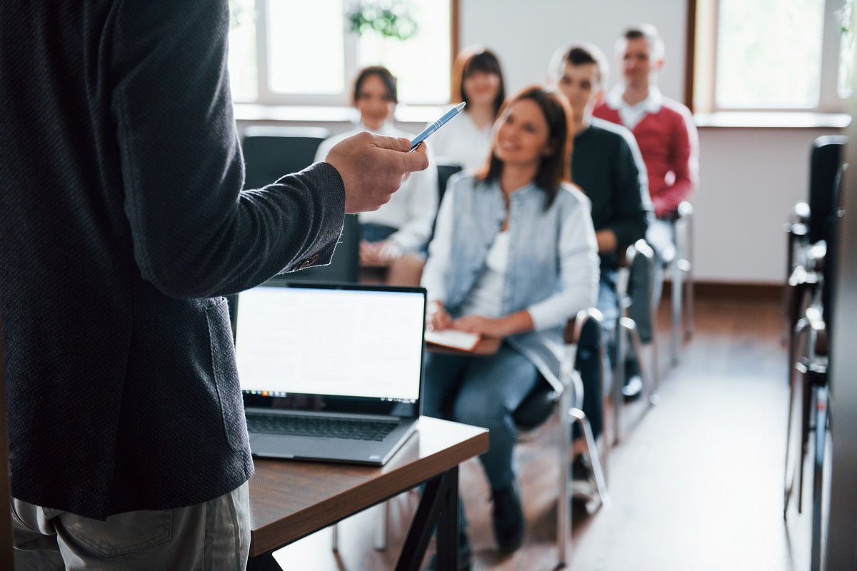 Das Foto zeigt eine Gruppe von Menschen, die jemandem gespannt zuhört. Als Coach kannst du online Geld verdienen und dabei noch anderen Menschen helfen.