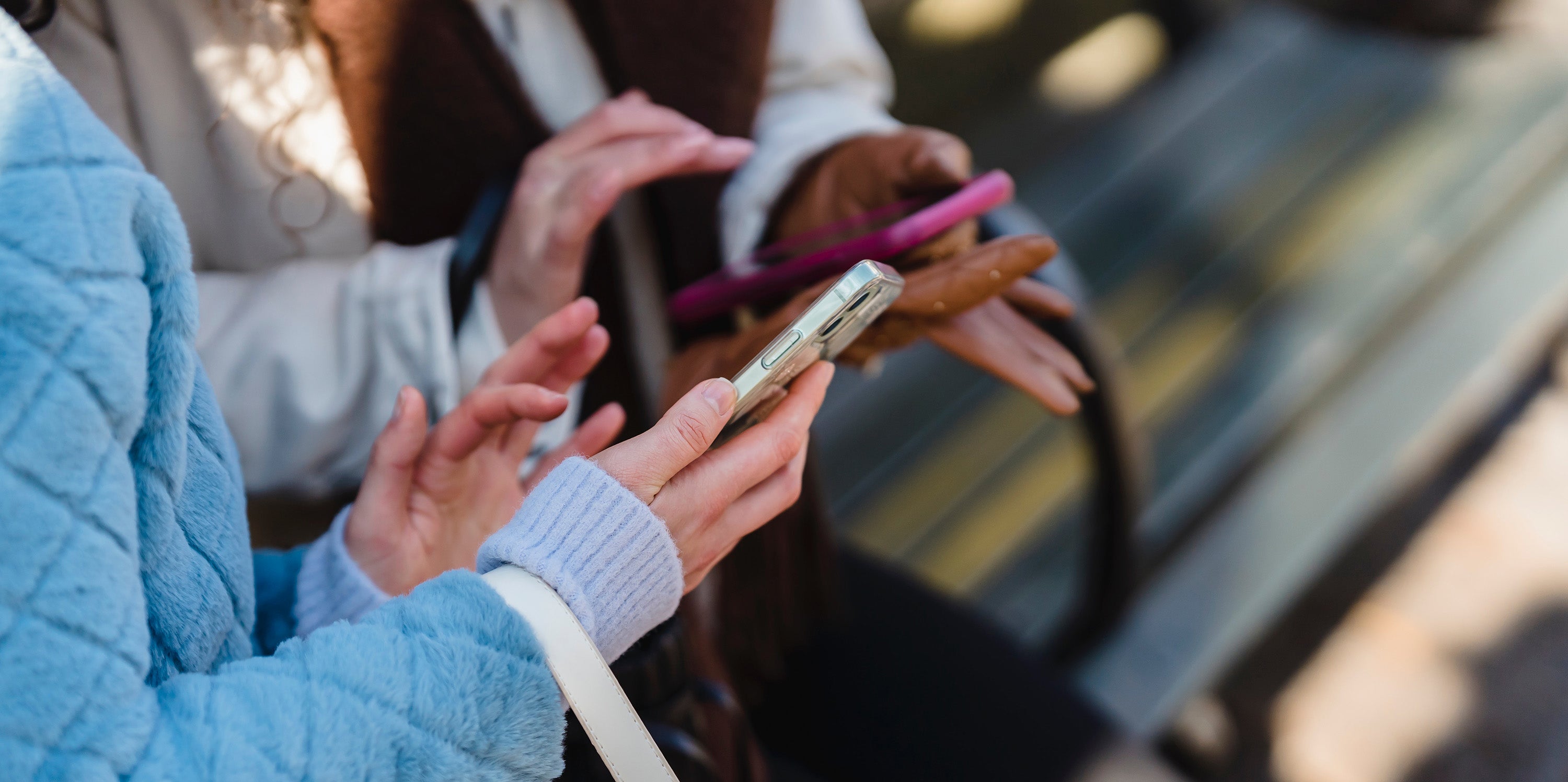 Gezeigt sind einige Personen, die Smartphones in ihren Händen halten.