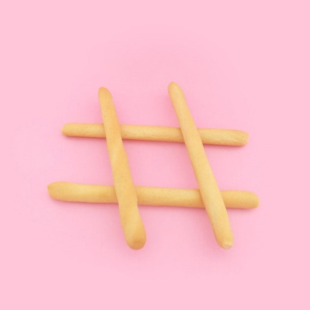 Hashtag-Symbol dargestellt aus Pommes auf rosafarbenem Hintergrund