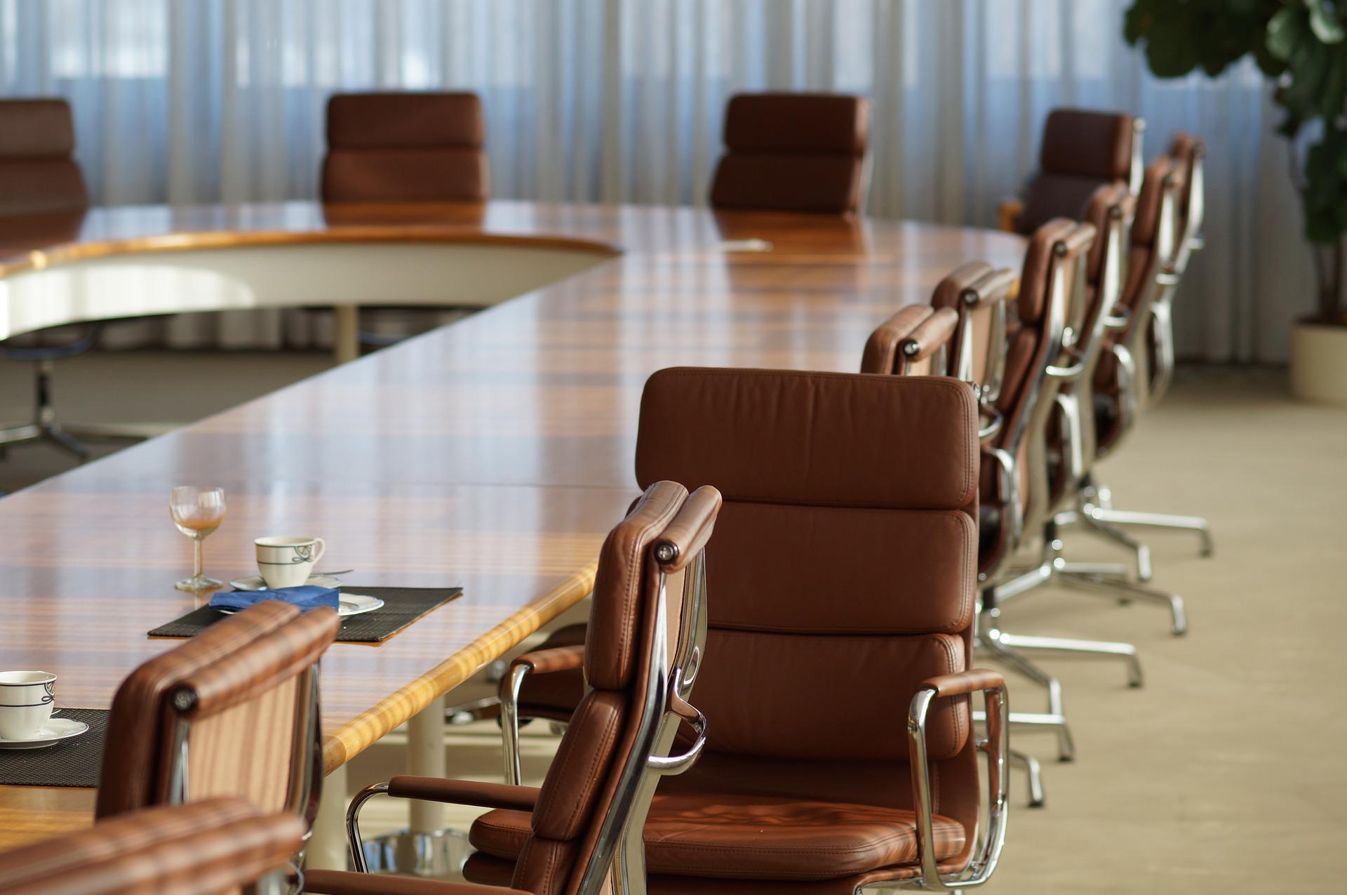 Blick in einen Konferenzsaal in dem braune Lederstühle um ein aus Tischen geformtes U stehen. Ein Stuhl ist so gedreht, als ob gerade jemand aufgestanden ist. Im Vordergrund sind auf den Tischen Tassen und Besteck zu sehen. Du musst Rahmenbedingungen festlegen und kommunizieren, damit der Verkauf von Produkten aus China nicht zum Reinfall wird.