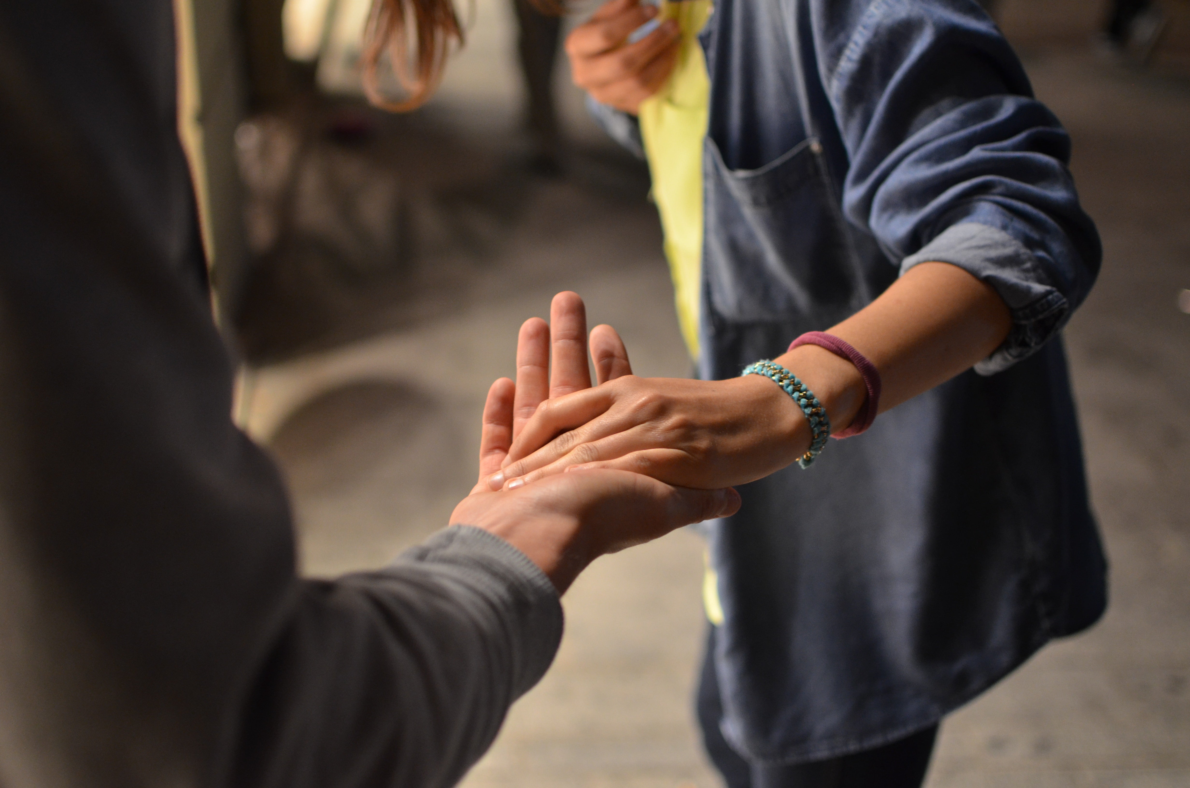 Zwei Menschen geben sich die Hand, um sich gegenseitig zu unterstützen.