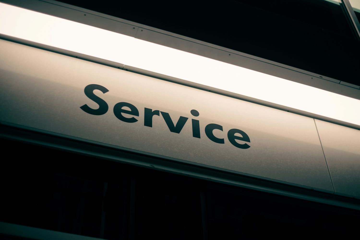 Zu sehen ist ein beleuchtetes Schild, auf dem „Service“ steht.
