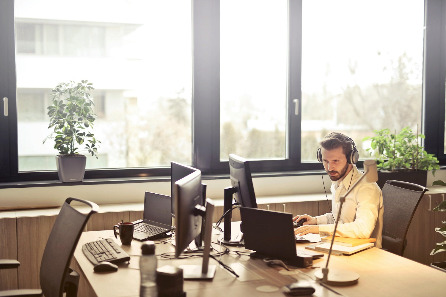 Das Foto zeigt einen Mann, der in einem Büro am Schreibtisch sitzt und ein Headset trägt. Shop Pay ermöglicht es dir, deinen Kund:innen einen schnelleren Support zu bieten.