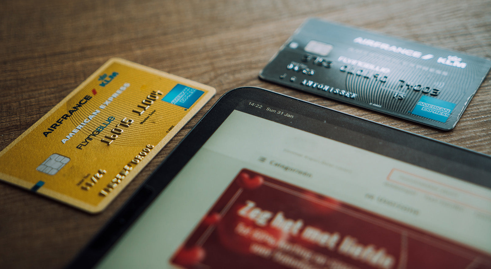 Neben einem Tablet liegen zwei Kreditkarten, die mit Shopify Payments akzeptiert werden